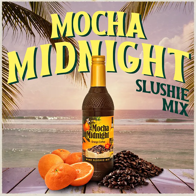 Bottle of Mocha Midnight slushie mix with oranges and coffee beans on a beach setting