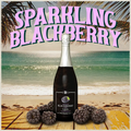 Bottle of sparkling blackberry wine on a beach with palm trees and ocean in the background.