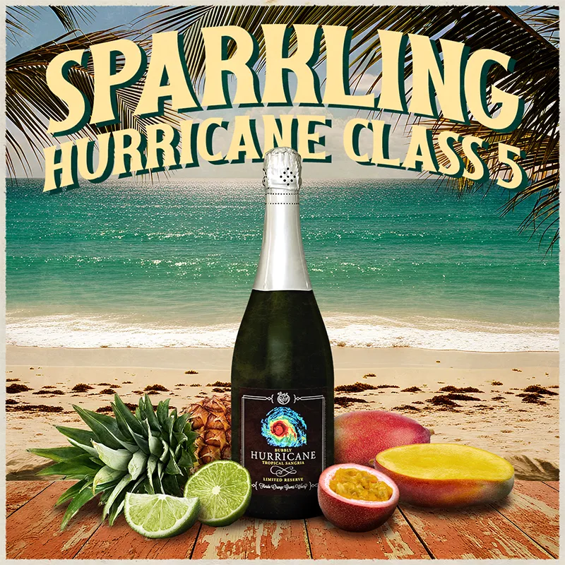 Bottle of Hurricane sparkling wine with tropical fruits on a beach setting