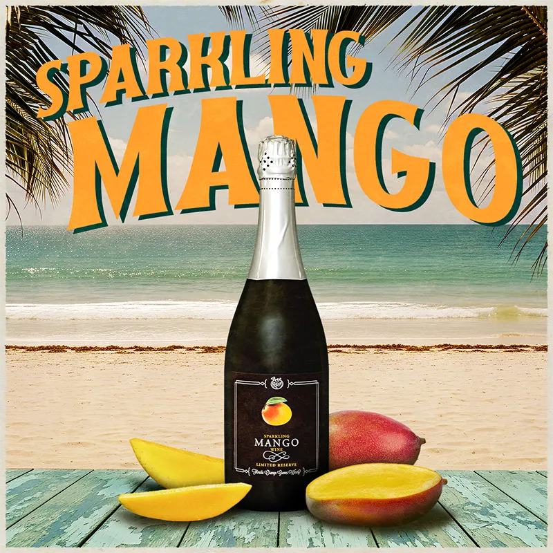 Bottle of sparkling mango wine with mango slices on a beach background