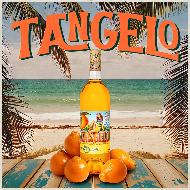 Bottle of Tangelo wine with oranges on a beach setting